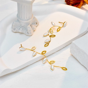 Elegante gouden blad oorbellen met witte parels op minimalistische voetstukken