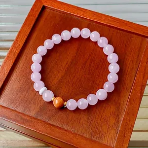 Lavender kunzite beaded bracelet with gold spacers and ginger accents on wooden tray