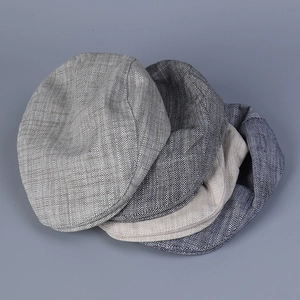 Flat lay of four herringbone flat caps in grey, beige, and navy for a vintage British look