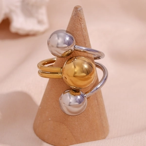 Detail of adjustable two-tone stainless steel ring featuring three metal beads on a stand