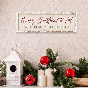 Close-up of wooden Merry Christmas wall plaque with candles and pine needles on a mantel