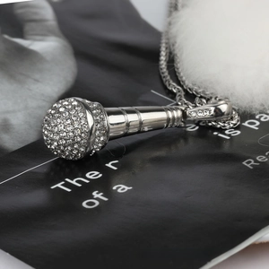 Detailed macro view of hip hop microphone pendant with white rhinestones on silver chain