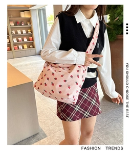 Detail of pink corduroy shoulder bag with strawberry print and soft textile texture