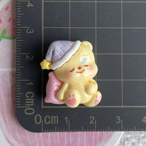 Detailed view of yellow bear resin charm on scale mat for DIY craft sizing
