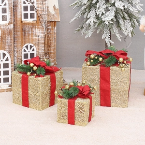 Three-piece gold mesh Christmas gift boxes with red ribbons and pine accents for decor