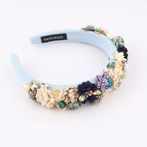 Detail of light blue sponge headband featuring 3D handmade flowers and pearl accents