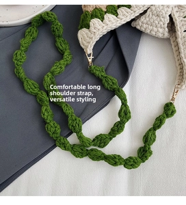 Close-up of green crochet shoulder strap with golden metal swivel hooks and thick texture