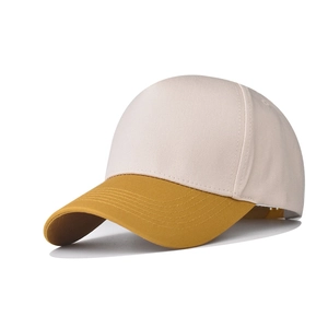 Detail of two-tone cotton baseball cap with beige crown and yellow stitched visor