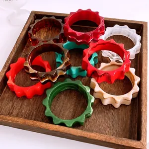 Bracelets en résine acrylique en forme d'engrenage de couleurs sur plateau bois