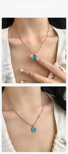 Detailed view of titanium steel necklace with an oval blue cat-eye stone pendant