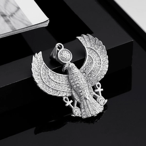 Detail of silver eagle pendant with crystals and Ankh symbols on reflective black surface