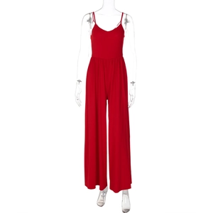 Detail of red backless jumpsuit featuring V-neck straps and wide leg knit fabric