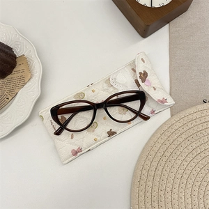 Padded cream-white eyewear pouch with cute bear print and cozy lifestyle setting