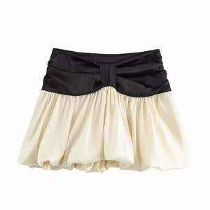 Detail eines farblich abgesetzten Rocks mit Schleife und Satin-Ballonsaum-Textur