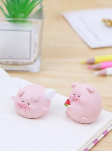 Cute pink resin mini pigs featuring white wings and watermelon on a clean desk setup