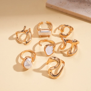 Vue détaillée d'un ensemble de sept bagues dorées avec perles et détails en émail chic