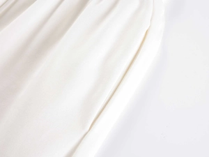 Macro shot of high-waist straight leg sweatpants showing cream white fabric texture