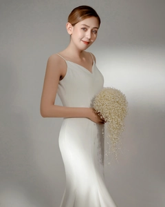 Detail of bridal cascade bouquet featuring white pearls paired with a V-neck wedding dress
