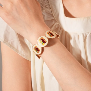 Detail of vintage gold enamel bracelet with geometric patterns on model's wrist