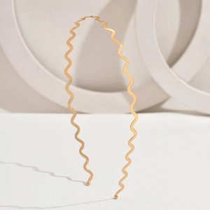 Minimalist golden wavy metal headband with sleek design and non-slip round tips