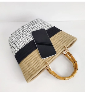 Bamboo handle detail on striped woven cotton tote bag with smartphone for size reference