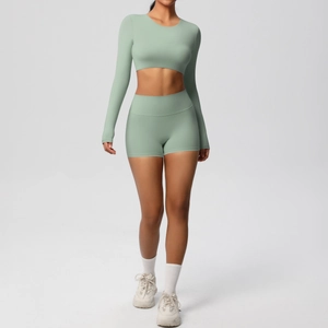 Detail of two-piece seamless yoga set with long sleeve crop top and high waist sports shorts