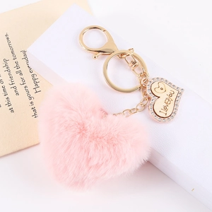 Plush pink heart keychain with golden I Love You pendant on white box and card