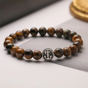 Bracciale di perle occhio di tigre con ciondolo ancora in argento su base moderna minimalista