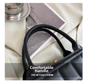 Detailed macro of the thickened round handle and quilted texture on a black handbag