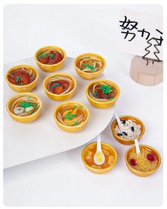 Macro shot of assorted 3cm miniature Chinese food models in gold bowls on white background