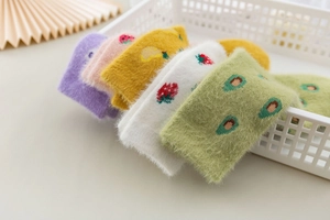 Detail of colorful plush mink velvet socks with fruit patterns in a storage basket