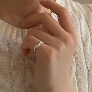 Minimalist S925 sterling silver ring with a sleek wavy design worn on the finger