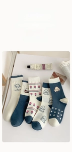 Détail de cinq paires de chaussettes en coton bleu marine et blanc aux motifs mignons