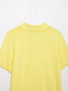 Close-up of bright yellow knit short sleeve polo top showing detailed ribbed collar texture