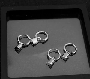 Detailed close-up of silver punk padlock earrings on a black display box