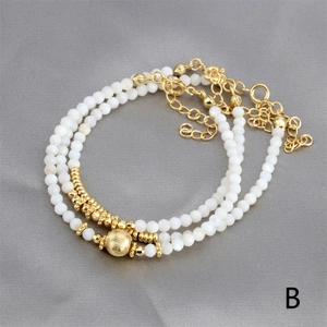 Detail of adjustable triple-layer white bead bracelet with textured gold-plated accents