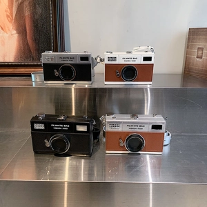 Mini camera-shaped crossbody box bags in silver, black, and brown with chain straps