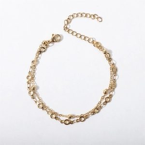 Detail of gold double-layered bracelet with metal beads and adjustable lobster clasp