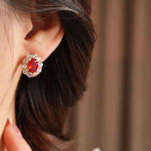 Nahaufnahme der Vintage Gold-Ohrringe mit ovalem rotem Zirkon und Diamant-Halo