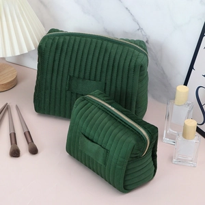 Detailed close-up of a two-piece green corduroy cosmetic bag set on a vanity table