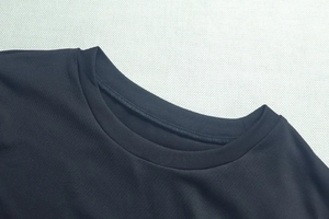 Détail de l'encolure ronde renforcée sur un ensemble deux pièces en maille noire