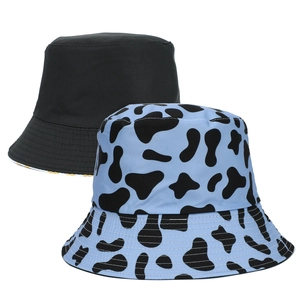 Dettaglio di un cappello da pescatore reversibile nero e blu con stampa mucca in cotone