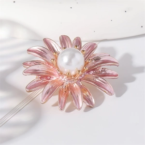 Elegant daisy flower brooch with pink enamel petals and center pearl on white surface