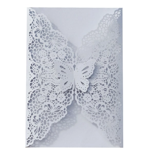 Close-up of white laser-cut wedding invitation featuring a hollow butterfly and lace pattern