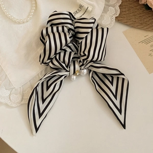 Detail of striped bow scrunchie with pearl accents and vintage ribbon streamers