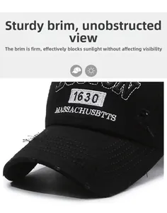 Detail of distressed brim with embroidery on retro black cotton baseball cap