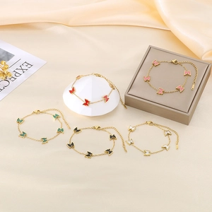 Detail of five colorful butterfly bracelets in pink, red, green, black and white on silk