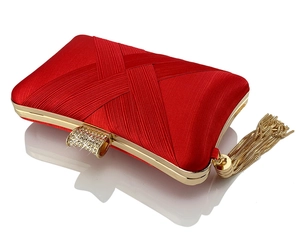 Close-up of red satin evening clutch bag with gold tassel charm and rhinestone clasp