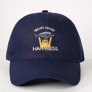 Détail d'un chat jaune brodé avec poisson et texte HAPPINESS sur une casquette bleu marine