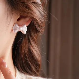 Elegant pearly pink acrylic bow earrings with silver needles for a minimalist sweet style